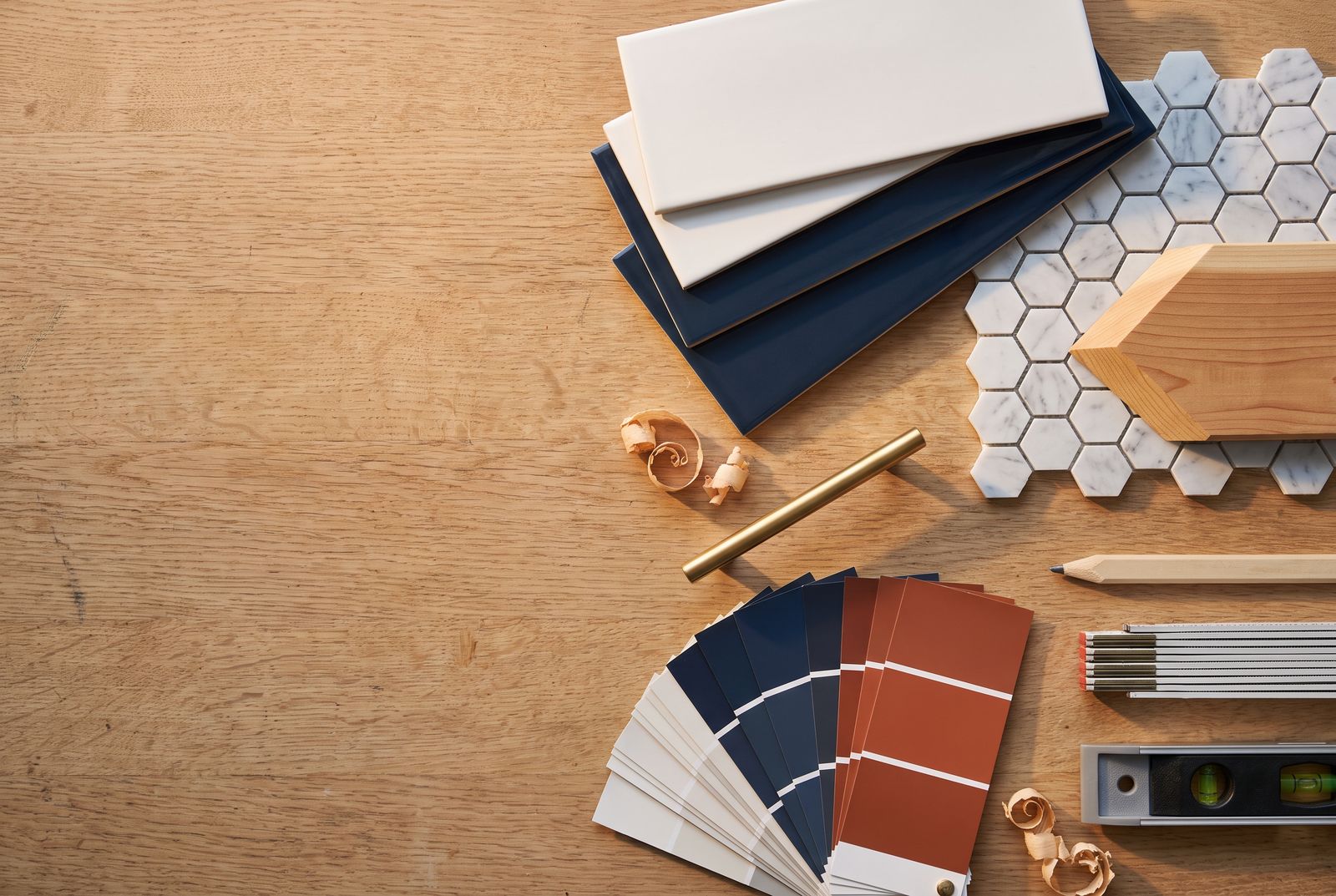 Tile, cedar, brass hardware and paint samples laid out on a workbench