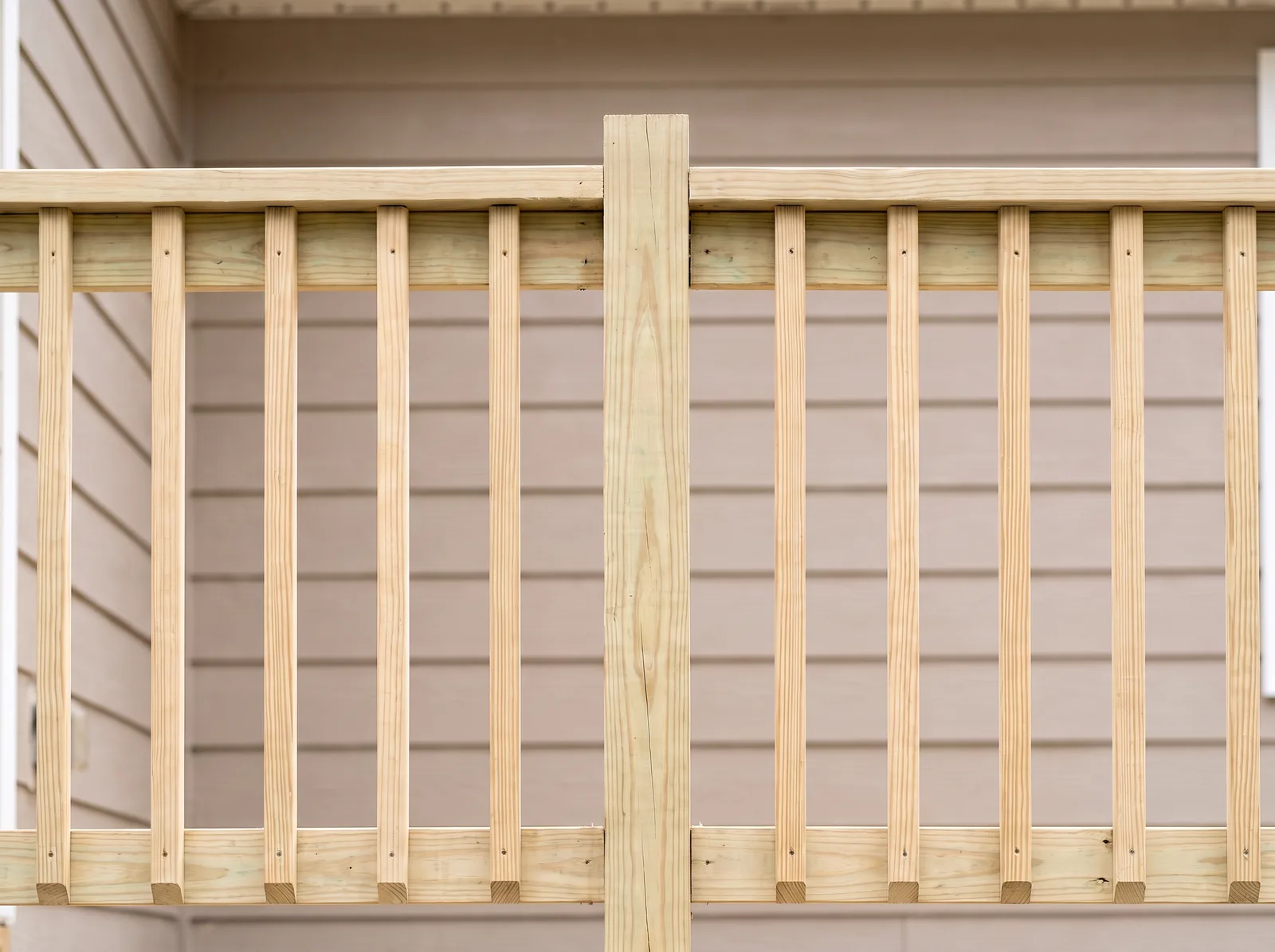 A 4x4 rail post with a plain flat top between the top and bottom rails and square wood pickets